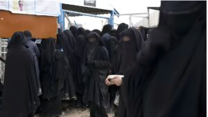 نساء يتجولن داخل مخيم الهول  الذي يضم عائلات عناصر من تنظيم الدولة شمال شرقي سوريا - 23 تشرين الأول 2025 (فرانس برس)