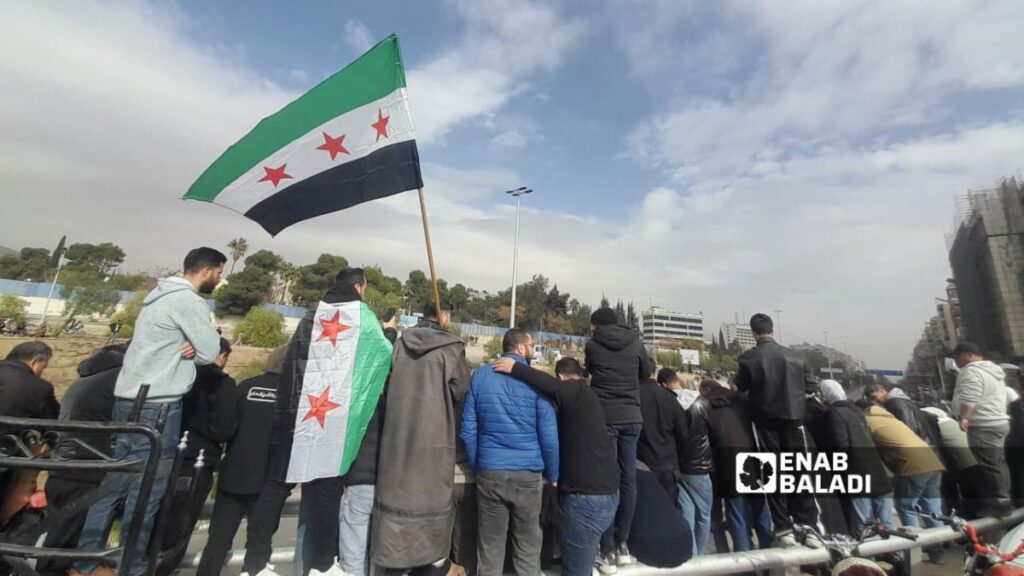 سوريون يشاهدون العرض العسكري في دمشق بذكرى التحرير الأولى – 8 كانون الأول 2025 (عنب بلدي/ نور حمزة)