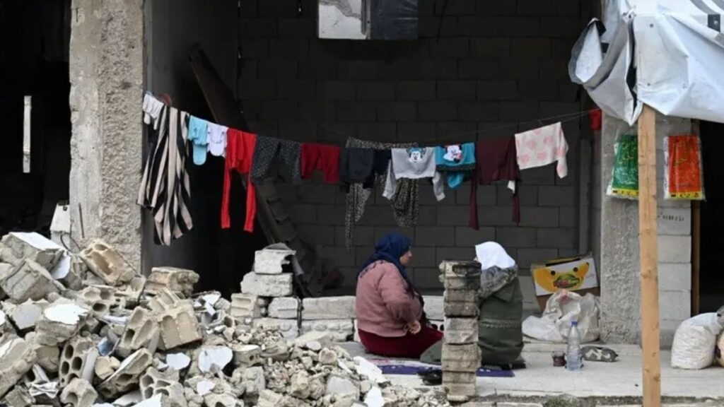 سيدتان تتبادلان الأحاديث في أحد أحياء حمص - 13 شباط 2025 (فرانس برس)