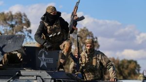 مقاتلون في صفوف قوات سوريا الديمقراطية ينتشرون على الطريق المؤدي إلى سجن غويران في الحسكة - 19 كانون الثاني 2026 (AP)