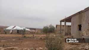 أحد سكان قرية حمادة عمر بناحية عقيربات في ريف حماة الشرقي يبني خيمة بجانب منزله المدمر  -  22 كانون الثاني 2026 (عنب بلدي)
