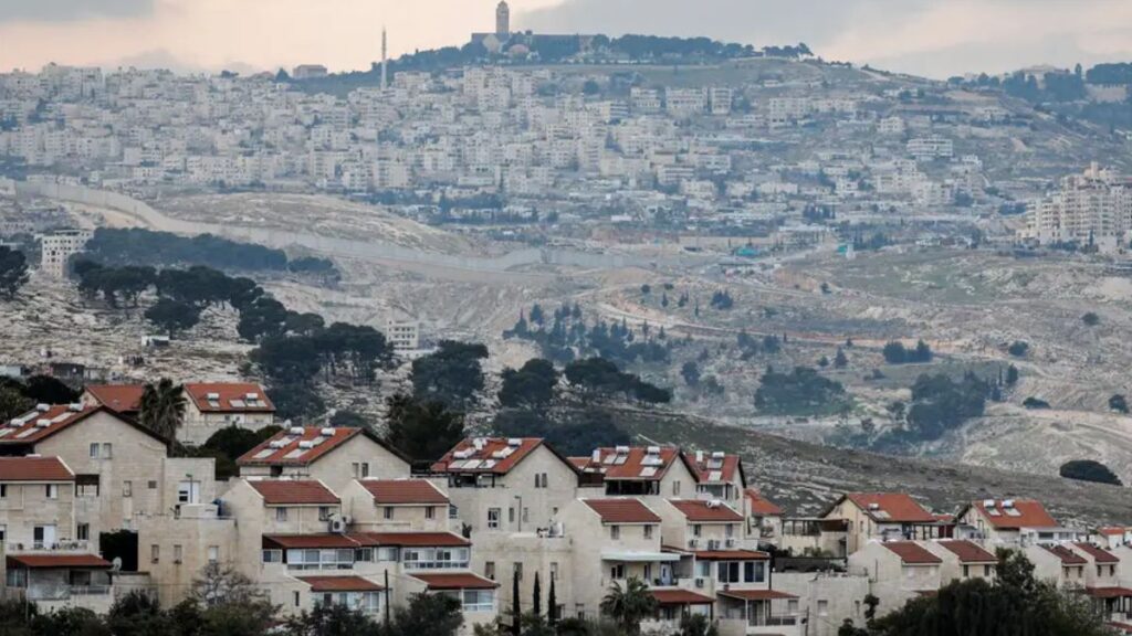 صورة أرشيفية - مستوطنة إسرائيلية والقدس في الخلفية. ترى منظمة "السلام الآن" الإسرائيلية غير الحكومية التي تعارض الاستيطان أن حكومة نتنياهو تعتزم "توسعة" القدس عبر ضم أراضٍ في الضفة الغربية إليها، في سابقة من نوعها منذ 1967 ( Menahem Kahana/AFP/Getty Images)
