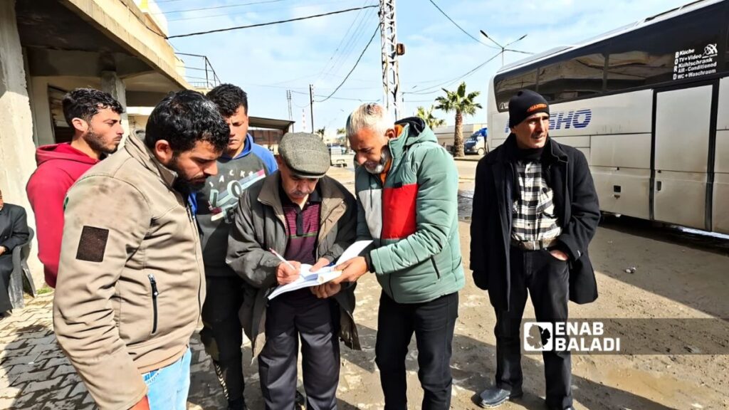 سوريون يسجلون أسماءهم لدى إحدى شركات النقل للسفر من رأس العين إلى الداخل السوري - 19 شباط 2026 (عنب بلدي/ حسين الشعبو)