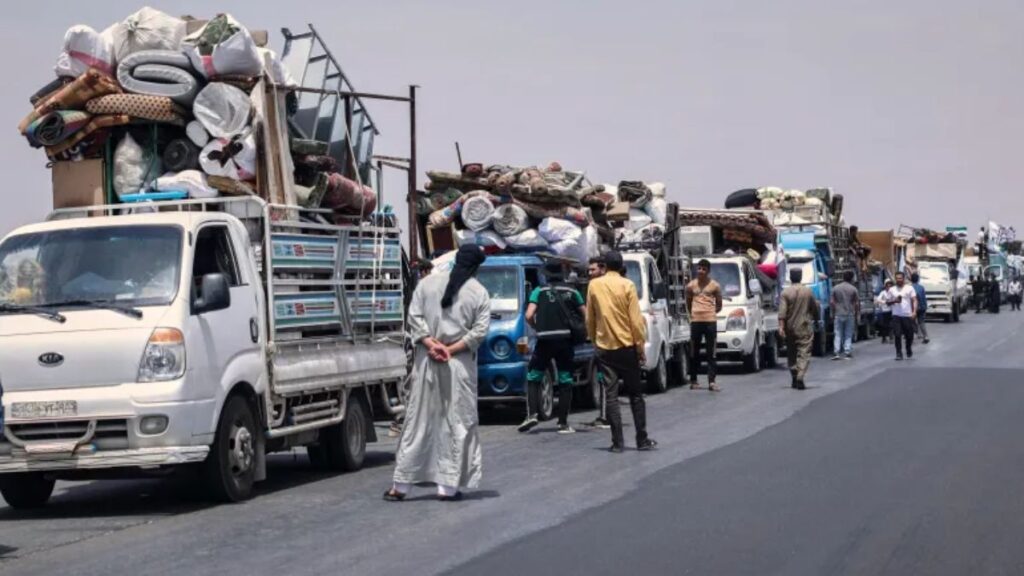 شاحنات تحمل نازحين سوريين عائدين لديارهم بقرية كفر سجنة بعد أن أمضوا سنوات في مخيمات قرب الحدود مع تركيا ـ 23 أيار 2026 (أسوشيتد برس)