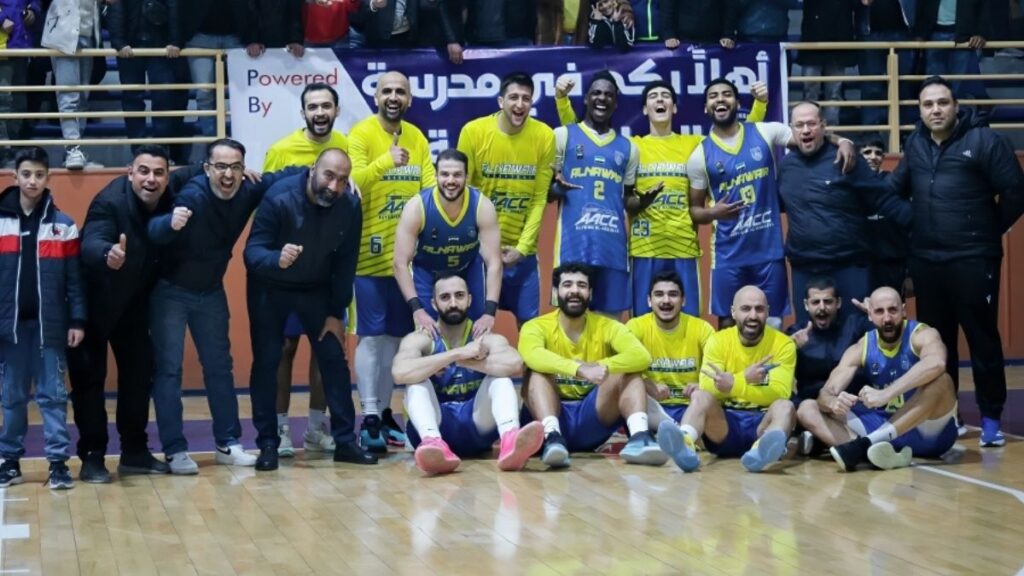 لاعبو وجهاز نادي النواعير يلتقطون صورة تذكارية مع جمهورهم احتفالًا بإنهاء مرحلة الذهاب في صدارة دوري كرة السلة - 10 آذار 2026 (نادي النواعير)