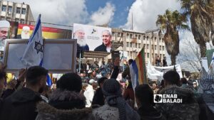 رفع صور لرئيس الوزراء الإسرائيلي بنيامين نتنياهو والشيخ حكمت الهجري خلال الاحتجاجات في السويداء - 11 نيسان 2026 (عنب بلدي)