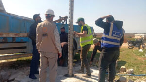 عمال من مؤسسة مياه حماة بالتعاون مع موظفين من منظمة 