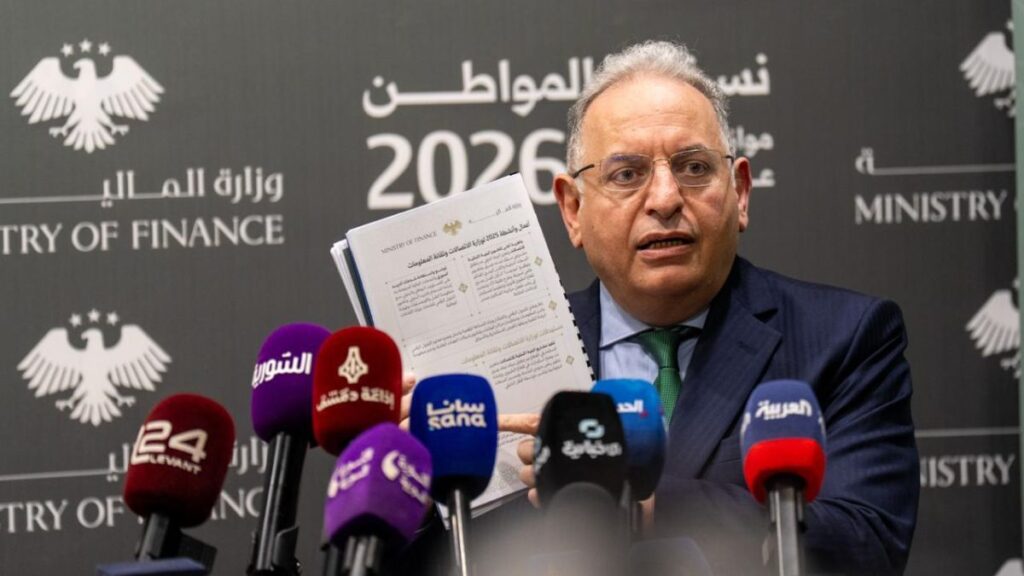 وزير المالية السوري محمد برنية يعرض في مؤتمر صحفي المطارح التي تم من خلالها تحقيق الفائض في موازنة 2025 - 9 نيسان 2026 (وزارة المالية السورية تلغرام)