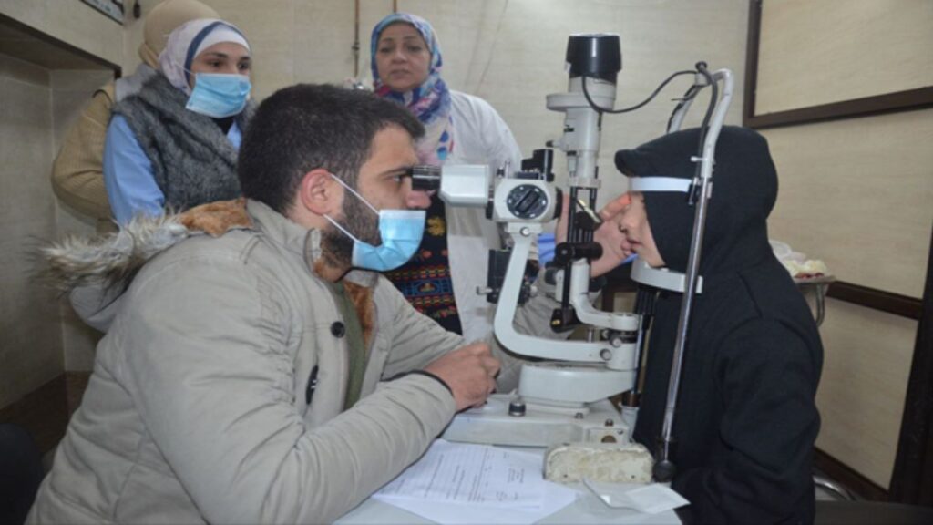 طبيب يفحص عيني مريضة في مستشفى حلب الجامعي- 18 كانون الأول 2025 (سانا)