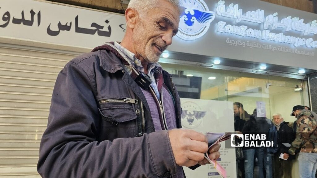 سوريون يقبلون على استبدال العملة في دمشق - 4 كانون الثاني 2025 (عنب بلدي/ أحمد مسلماني)