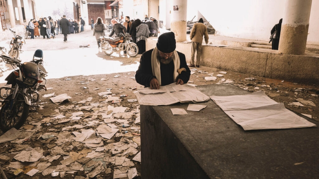 رجل يبحث عن أسماء أحد أقاربه بالسجلات والأوراق المبعثرة في سجن "صيدنايا" عقب سقوط النظام السوري - 9 كانون الأول 2024 (panos picture)