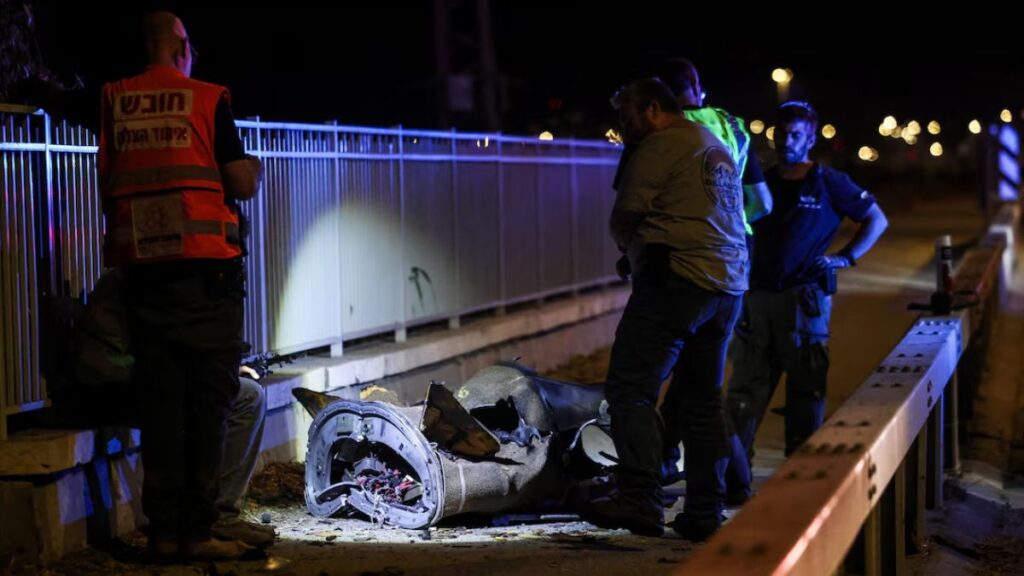 أفراد الأمن والإنقاذ الإسرائيليون يقفون بجوار جزء من قذيفة في أعقاب هجوم صاروخي من إيران باتجاه إسرائيل ـ 8 حزيران 2026 (رويترز/ شير تورم )