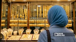 فتاة تقف أمام أحد محلات المصاغ في الحسكة - 6 تموز 2026 (عنب بلدي)
