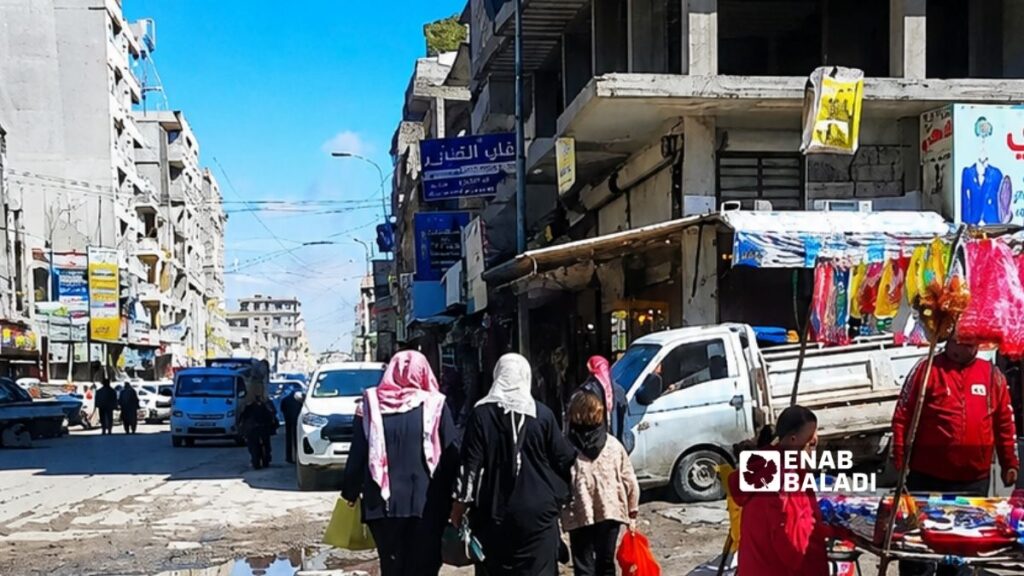 نساء أمام محل مجوهرات في شارع تل أبيض في مدينة الرقة - 11 نيسان 2026 (عنب بلدي/ أحمد الحمدي)