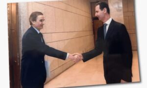 رئيس النظام المخلوع بشار الأسد يصافح ضابط الأمن حسام لوقا في صورة عثرت عليها بي بي سي في شقة الأخير بدمشق - 7 آب 2026 (BBC)