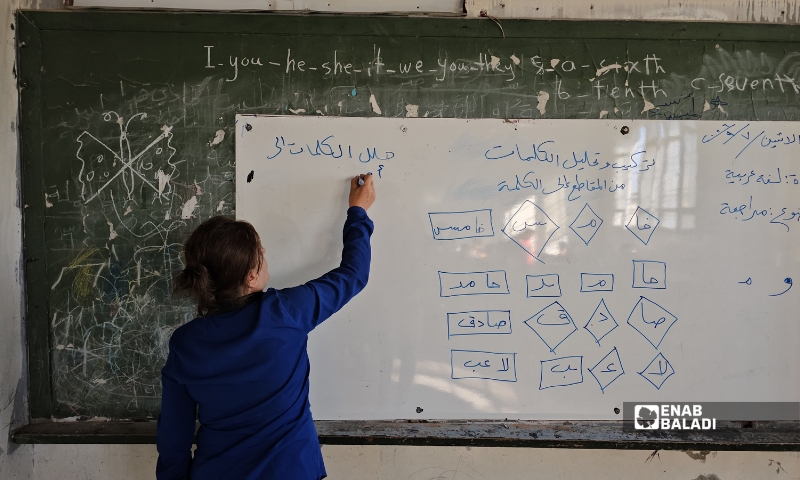معلمة تبدأ مراجعات للدروس في أحد الصفوف بمدرسة العزيزية في حماة مع انطلاق العام الدراسي - 6 أيلول 2026 (عنب بلدي)