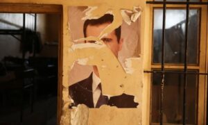 صورة ممزقة للرئيس المخلوع بشار الأسد على أحد جدران قاعدة عسكرية في دمشق - 15 كانون الأول 2024 (رويترز)