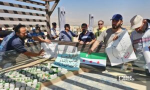 من اللافتات التي حملها المشاركون خلال المسيرة باتجاه موقع المشروع - 26 أيلول 2026 (عنب بلدي/ أحمد مسلماني)
