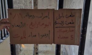 سجين في رومية يرفع عبارة تؤكد استمرار المساجين في الاعتصام لليوم الرابع - 16 أيلول 2026 (ناشطون من السجناء السابقين في رومية)