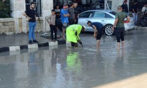 عنصر من الدفاع المدني السوري إلى جانب أهالِ يقومون بتصريف مياه الأمطار بحلب- 1 تشرين الأول 2026 (الدفاع المدني السوري)