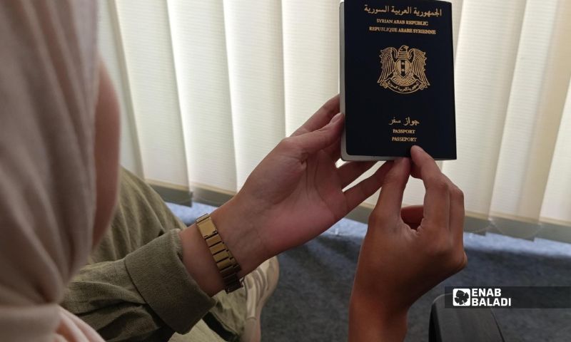 مواطنة سورية تتصفح جواز سفرها - 13 تشرين الأول 2026 (عنب بلدي)