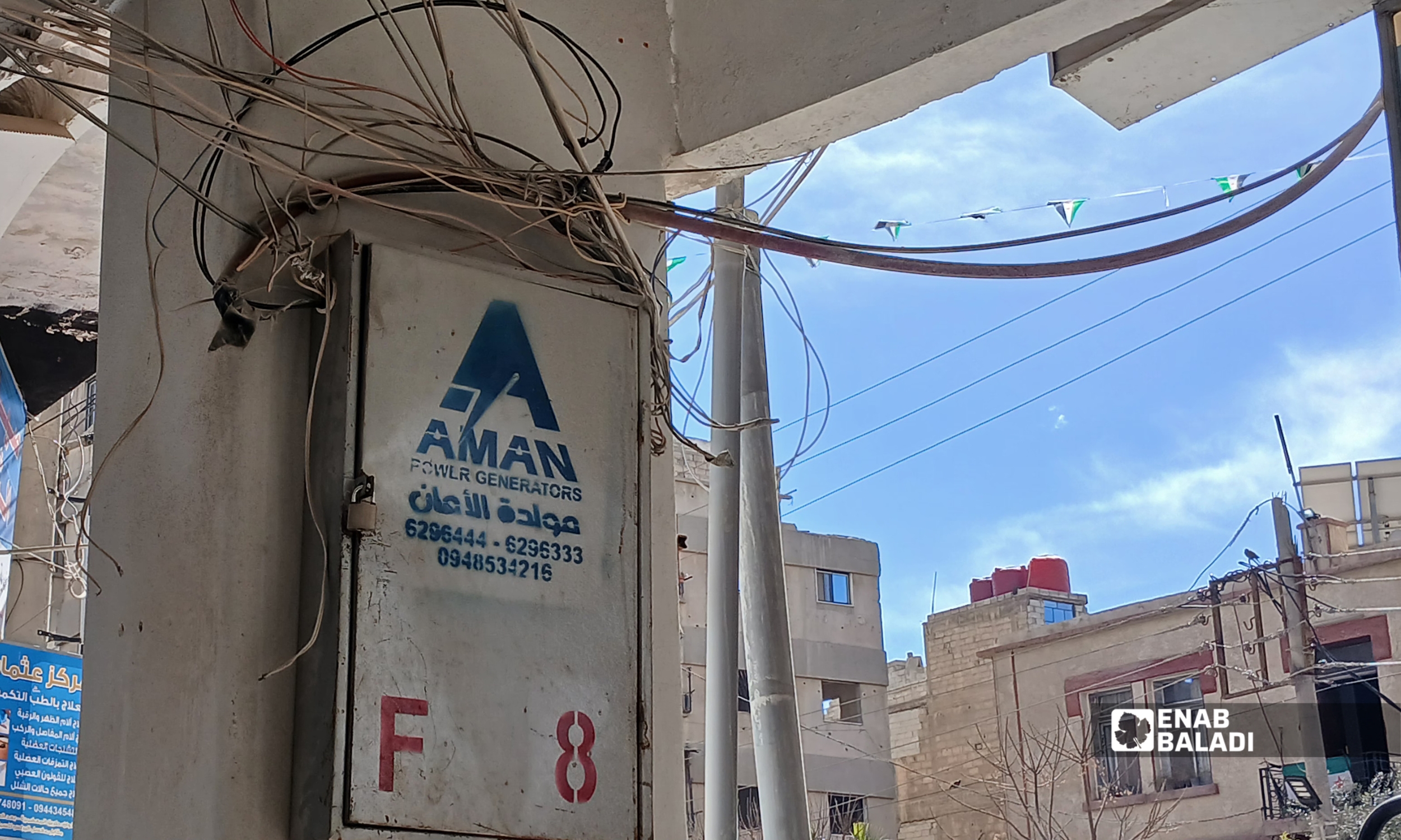 تمديدات أمبيرات وكابلات كهربائية عشوائية على واجهة مبنى سكني–تجاري في مدينة داريا بريف دمشق – 1 شباط 2026 (عنب بلدي – رزان أبو رشيد)
