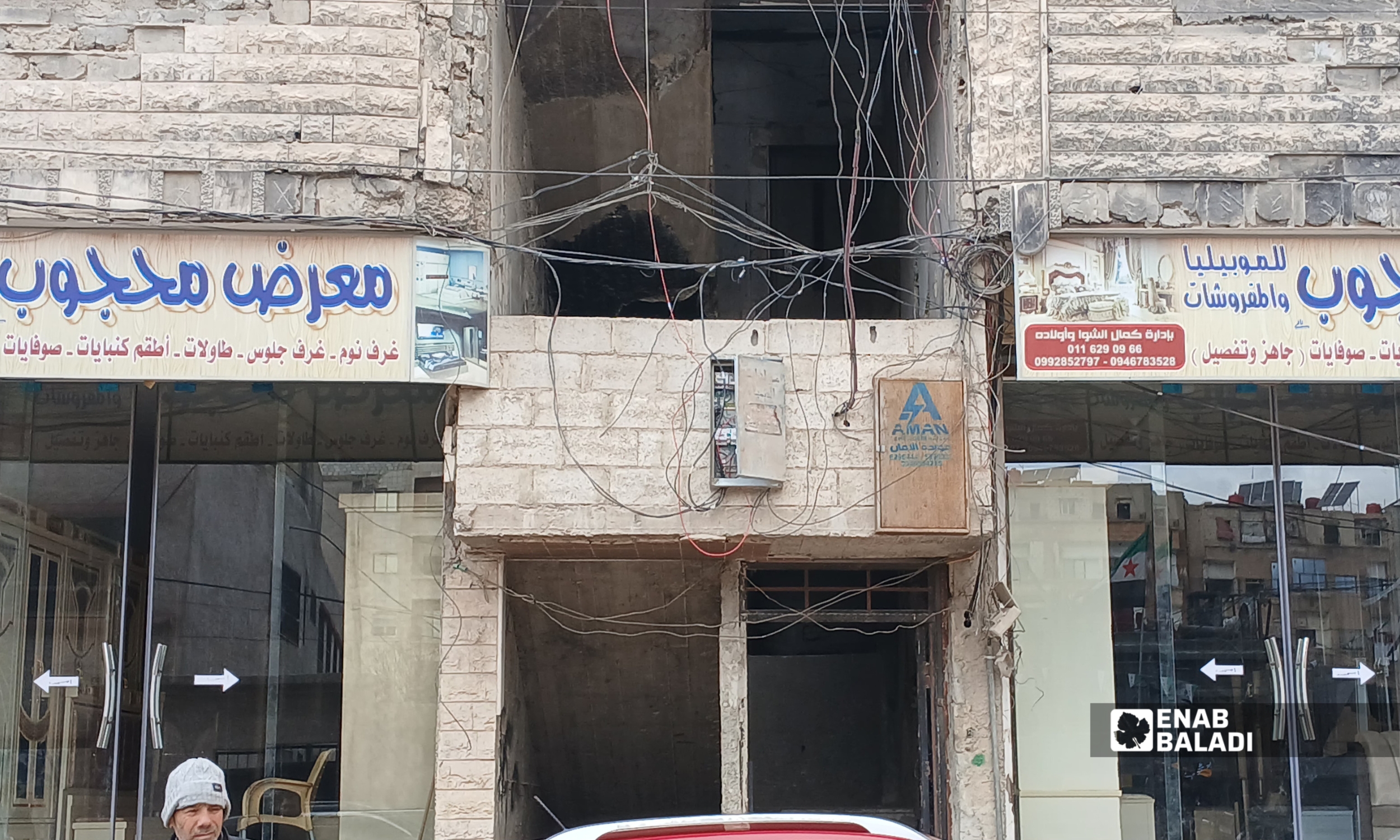 تمديدات أمبيرات وكابلات كهربائية عشوائية على واجهة مبنى سكني–تجاري في مدينة داريا بريف دمشق – 1 شباط 2026 (عنب بلدي – رزان أبو رشيد)