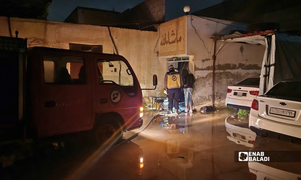عناصر من الدفاع المدني خلال الاستجابة لبلاغ عن دخول المياه إلى أحد المنازل في داريا 