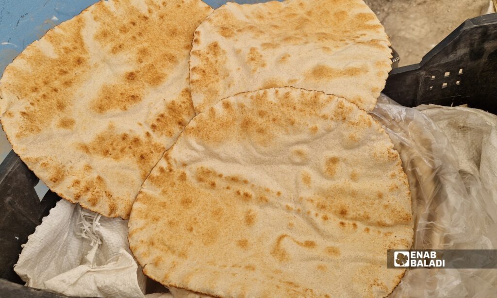 أهالٍ يشترون الخبز داخل فرن داريا الآلي في مدينة داريا