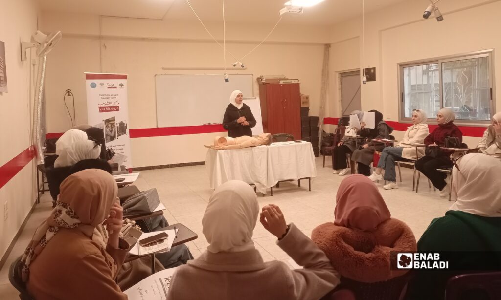 مدربة تشرح للمشاركات أساسيات الإسعافات الأولية خلال دورة تدريبية في داريا