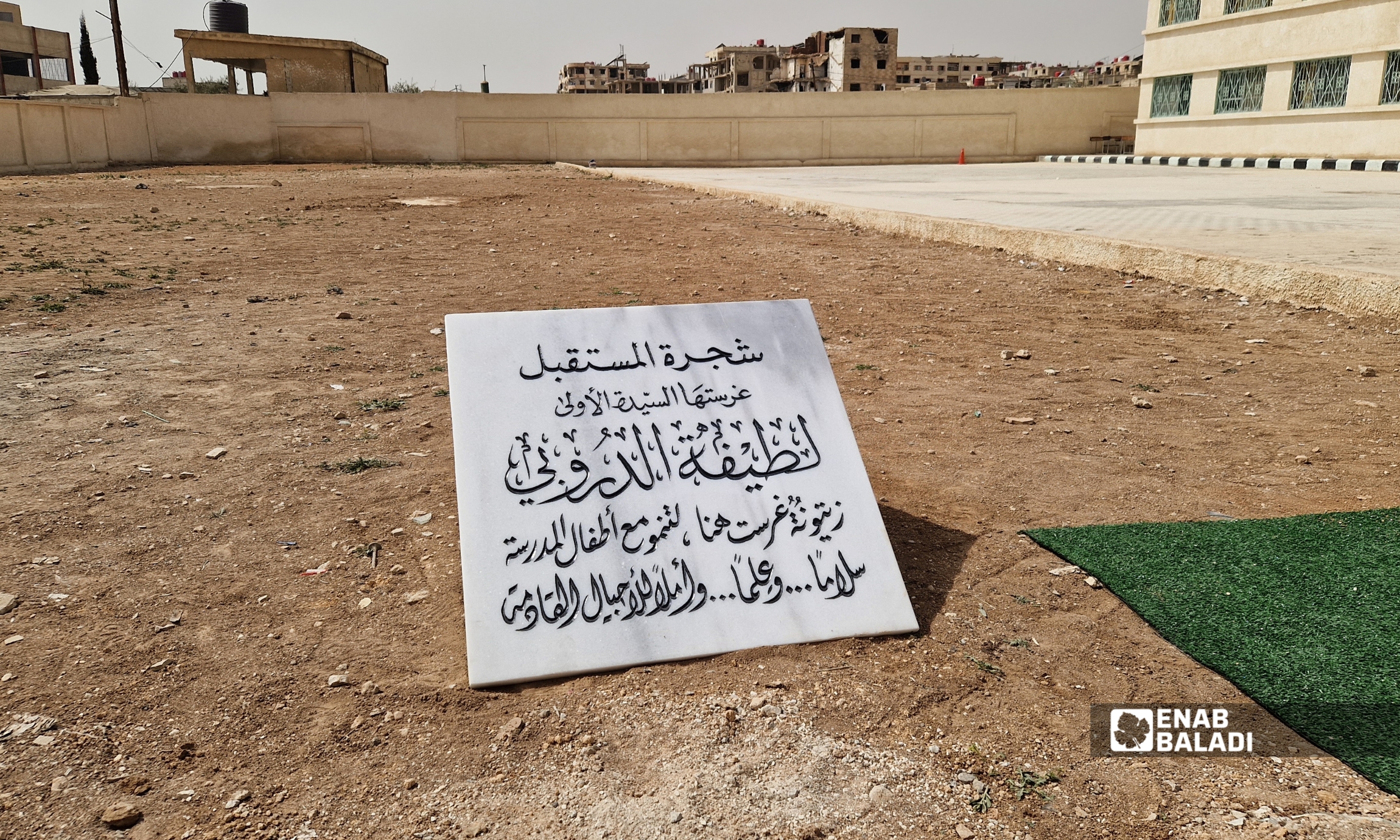 لطيفة الدروبي تزرع شجرة زيتون في باحة مدرسة “الإبداع للبنات” في داريا خلال زيارتها - 12 آذار 2026 (عنب بلدي - سعيد خشفة)