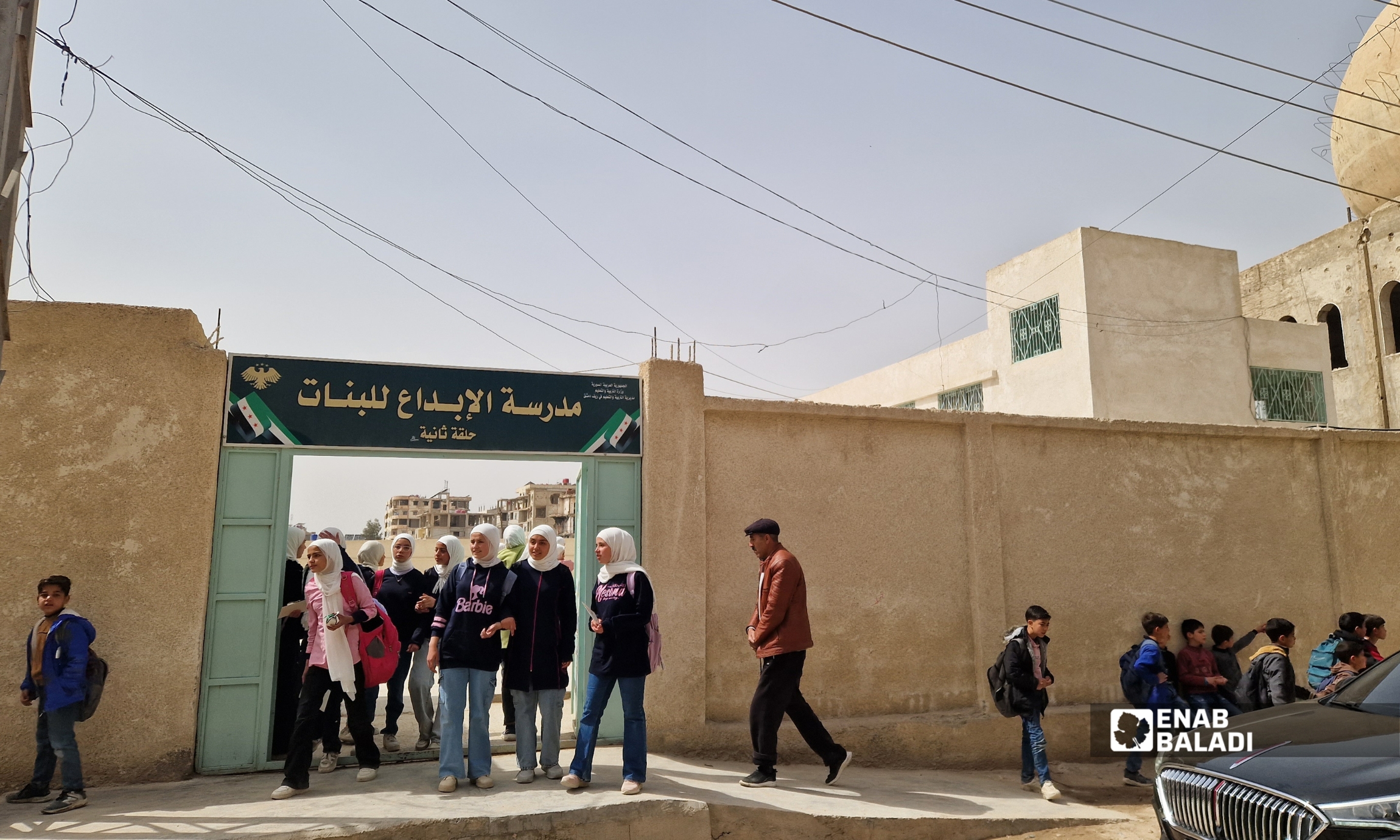 لطيفة الدروبي تزرع شجرة زيتون في باحة مدرسة “الإبداع للبنات” في داريا خلال زيارتها - 12 آذار 2026 (عنب بلدي - سعيد خشفة)