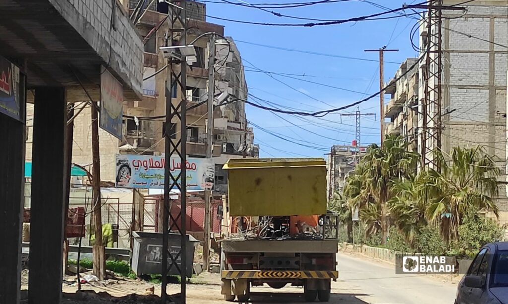 ورشة كهرباء تعمل على إصلاح عطل في الشبكة باستخدام رافعة خلف المخفر في مدينة داريا