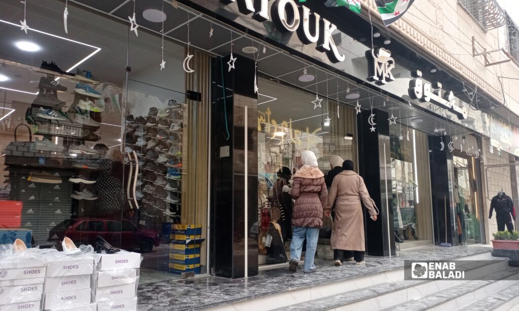 أهالٍ يتسوقون من أحد بسطات السوق في داريا مع اقتراب عيد الفطر