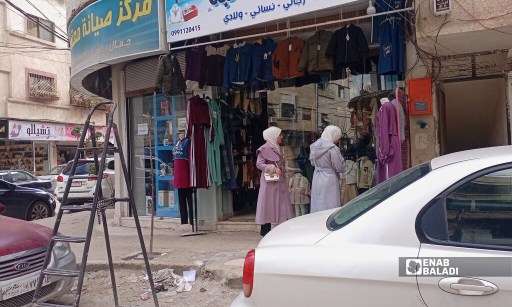 أهالٍ يتسوقون من أحد بسطات السوق في داريا مع اقتراب عيد الفطر