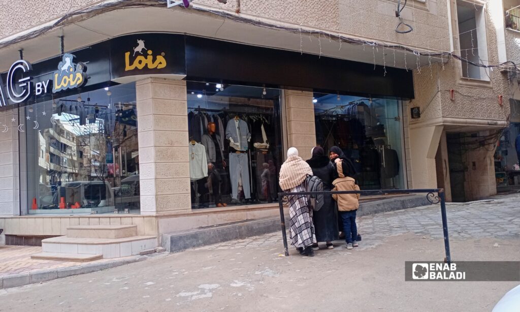 أهالٍ يتسوقون من أحد بسطات السوق في داريا مع اقتراب عيد الفطر