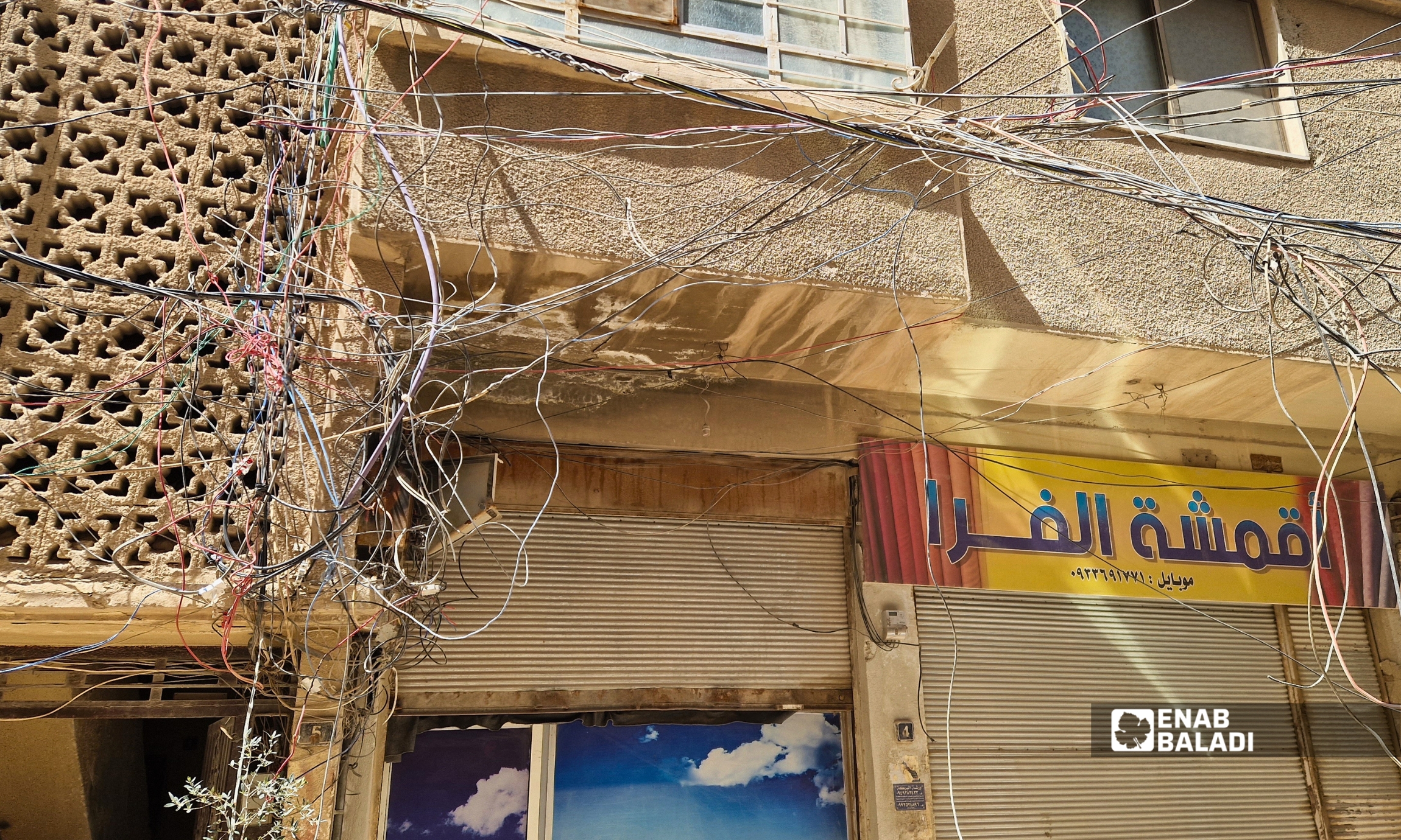 تمديدات كهربائية عشوائية ومتدلية في شارع مقابل مدرسة المحدثة للبنين بمدينة داريا بعد انقطاعها