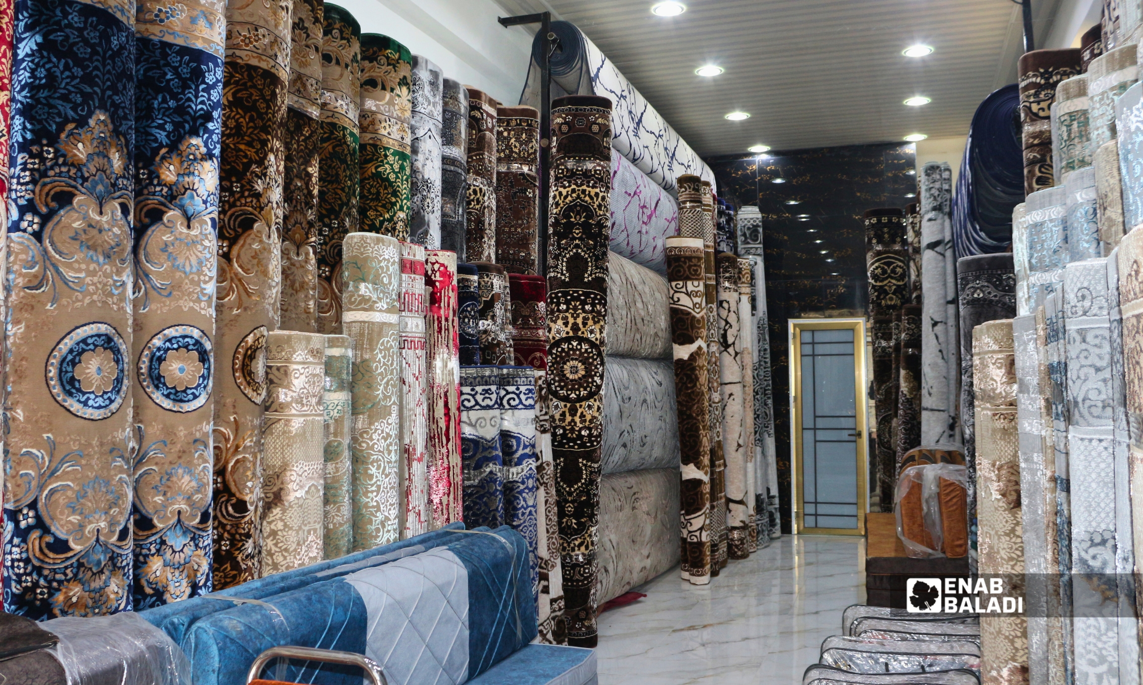 توسع تجاري في داريا.. محال وأسواق جديدة تنشط المدينة تحت ضغط الغلاء 25 سجاد معروض داخل أحد المحال التجارية في داريا