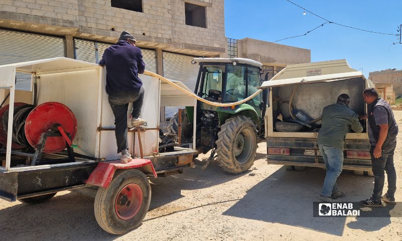 عمال من ورشات بلدية داريا أثناء صب أحد الريغارات على طريق القرية الصغيرة في المدينة 