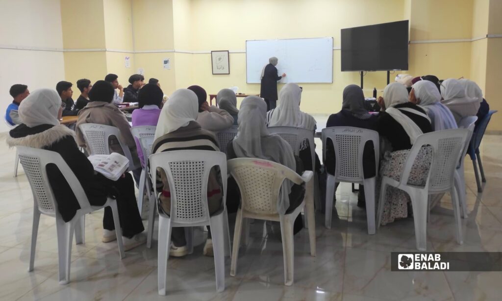 طلاب يتابعون إحدى جلسات دورات التقوية المجانية لطلاب التاسع والبكالوريا في المركز الثقافي بمدينة داريا