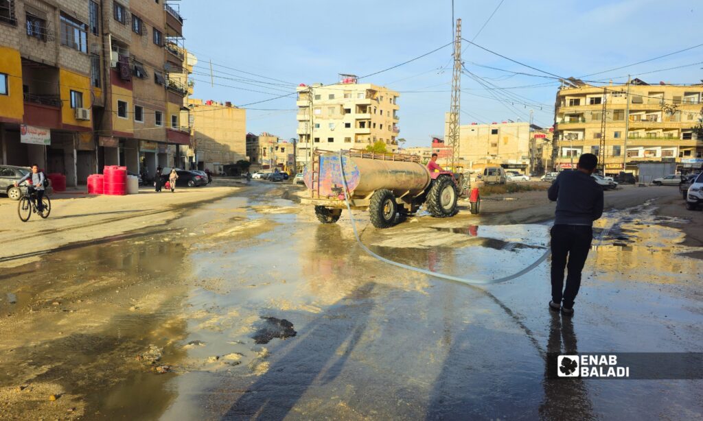 فتح إحدى فتحات الصرف الصحي في داريا بعد طفح المياه الآسنة في شوارع المدينة