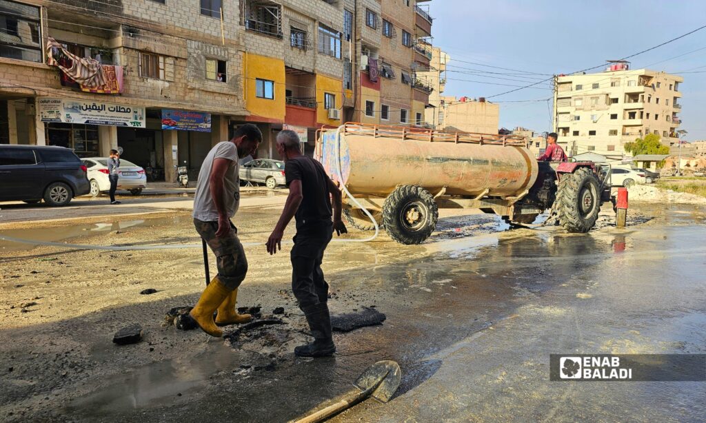 فتح إحدى فتحات الصرف الصحي في داريا بعد طفح المياه الآسنة في شوارع المدينة