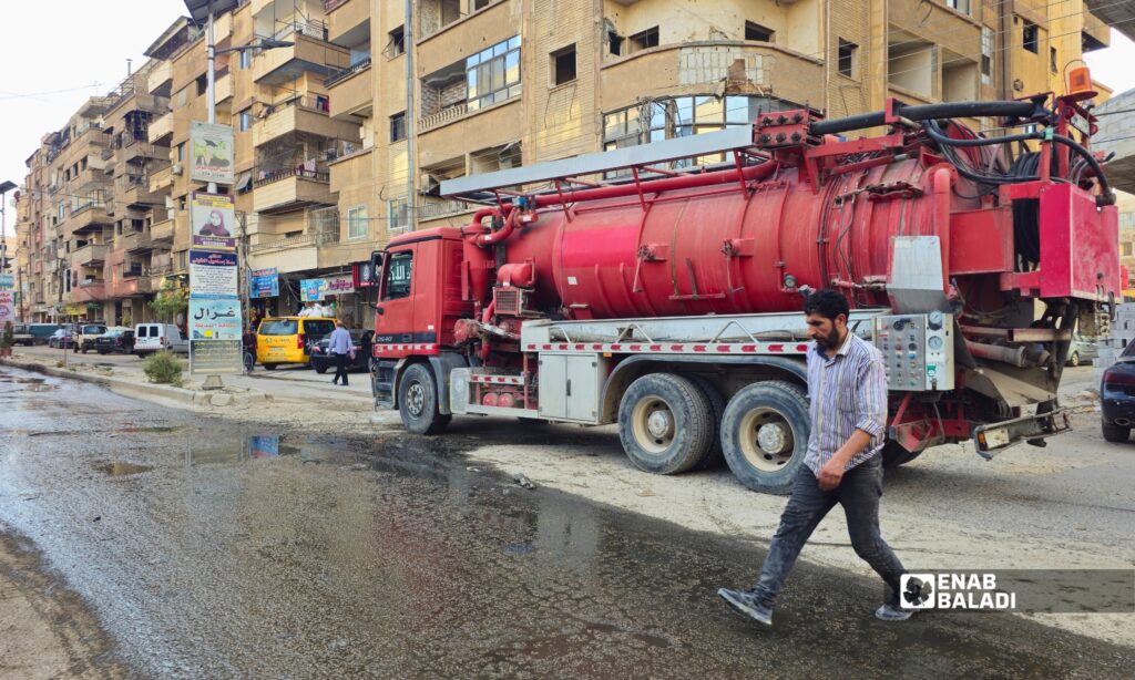 فتح إحدى فتحات الصرف الصحي في داريا بعد طفح المياه الآسنة في شوارع المدينة