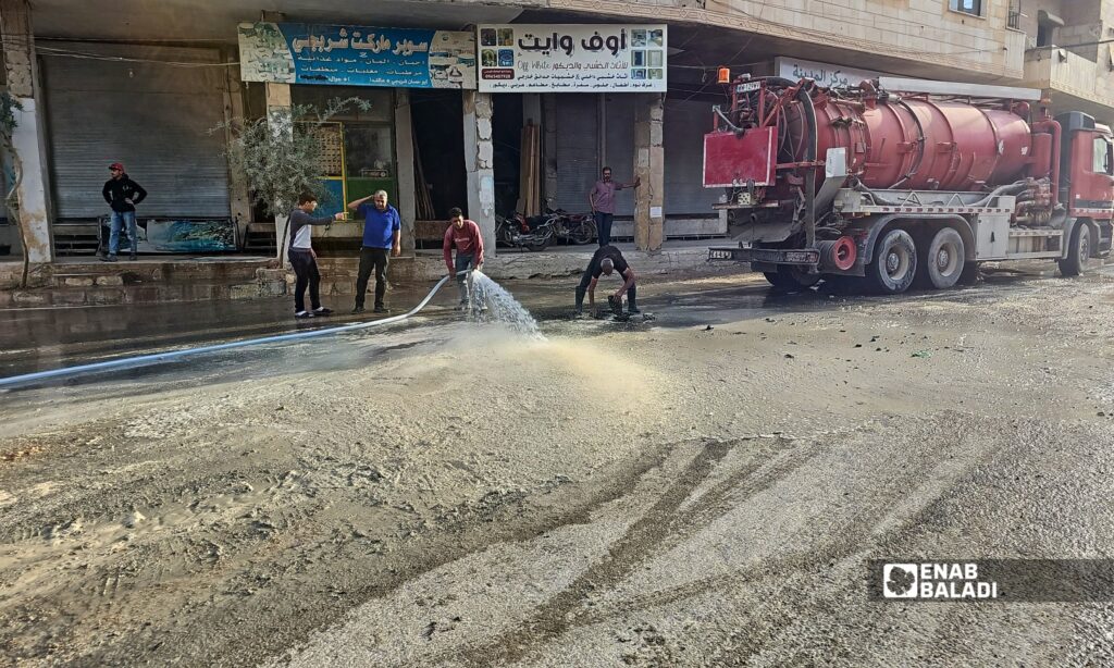 فتح إحدى فتحات الصرف الصحي في داريا بعد طفح المياه الآسنة في شوارع المدينة