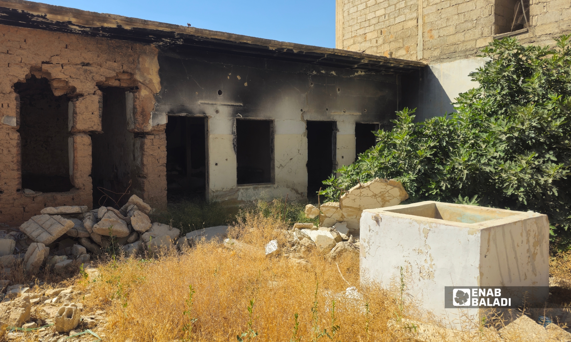 البيت الداراني القديم.. ذاكرة مدينة في الطين والخشب والحجر 16 بقايا "المصنع" في منزل يعود لعائلة شربجي في داريا الشمالية، ويظهر في المقدمة حوض المياه المخصص لغسيل الأواني والملابس والوضوء، وهو مرفق خدمي كان يبنى في نقطة معزولة عن غرف السكن و"بيت المونة" ضمن البيوت الدارانية التقليدية - 2026 (عنب بلدي - سعيد خشفة).