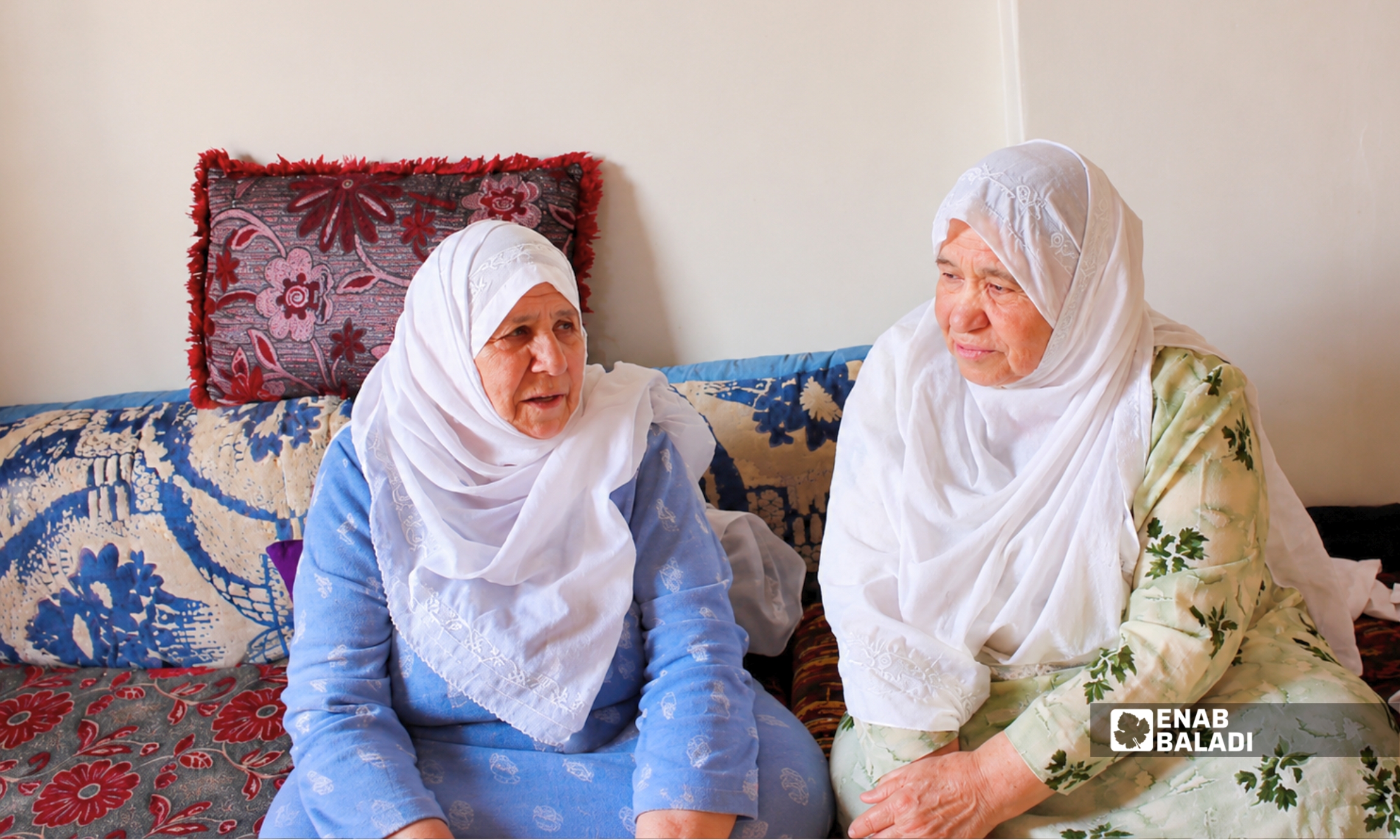 السيدتان أم عمر وأم جميل من داريا ترتديان الغطا الذي ارتبط بتراث المرأة الدارانية لعقود - 3 حزيران 2026 (عنب بلدي - نداء كناكرية)