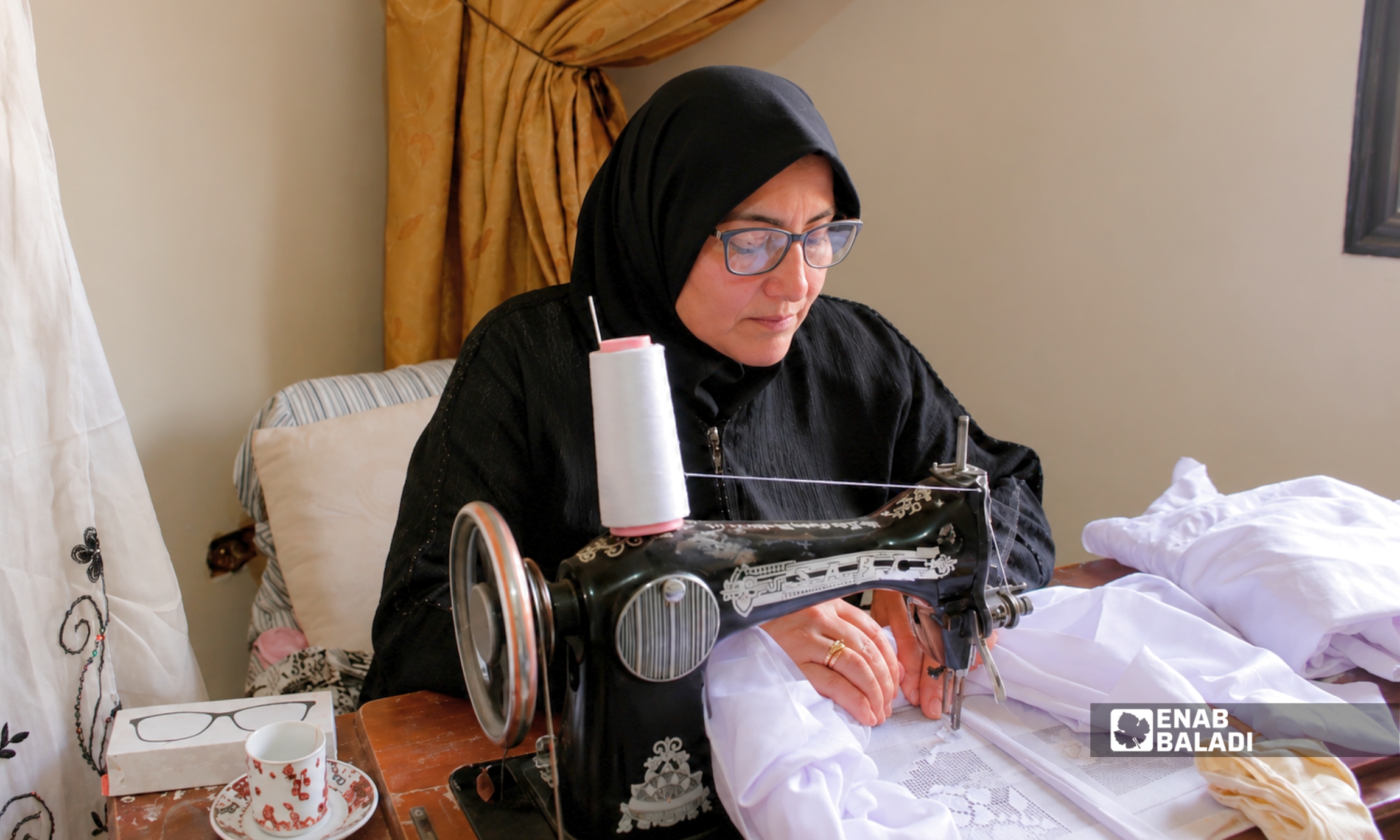 نهى عبد الباقي أثناء خياطة وتطريز أحد الأغطية الديرانية في داريا