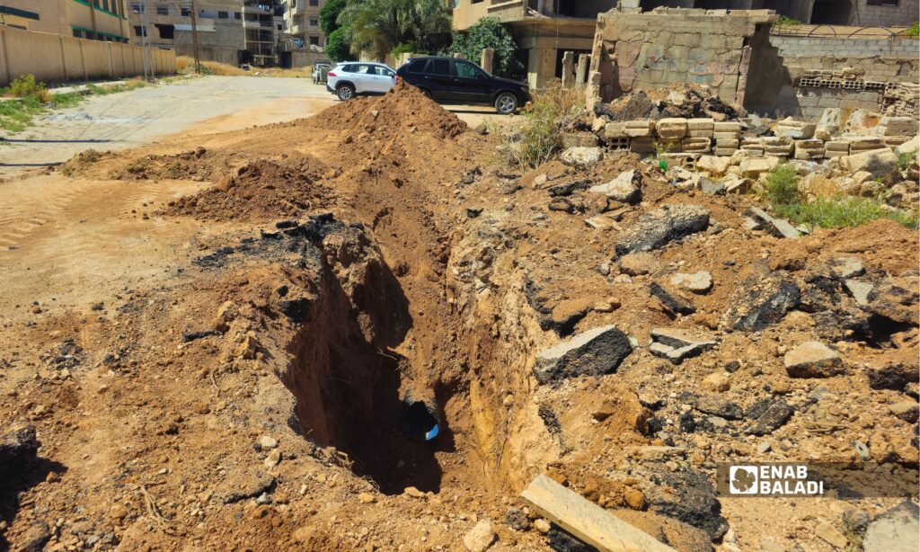عمال ينفذون أعمال إصلاح لشبكة الصرف الصحي في أحد شوارع داريا ضمن مشروع معالجة أعطال البنية التحتية وكشف المقاطع المتضررة تحت الطريق