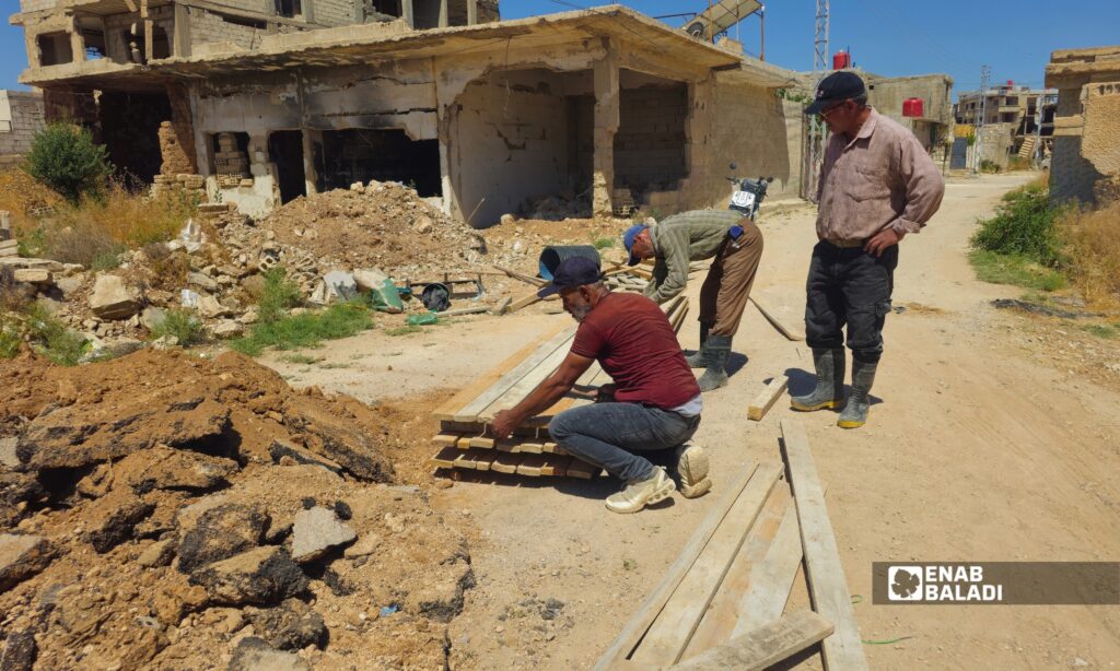 عمال ينفذون أعمال إصلاح لشبكة الصرف الصحي في أحد شوارع داريا ضمن مشروع معالجة أعطال البنية التحتية وكشف المقاطع المتضررة تحت الطريق