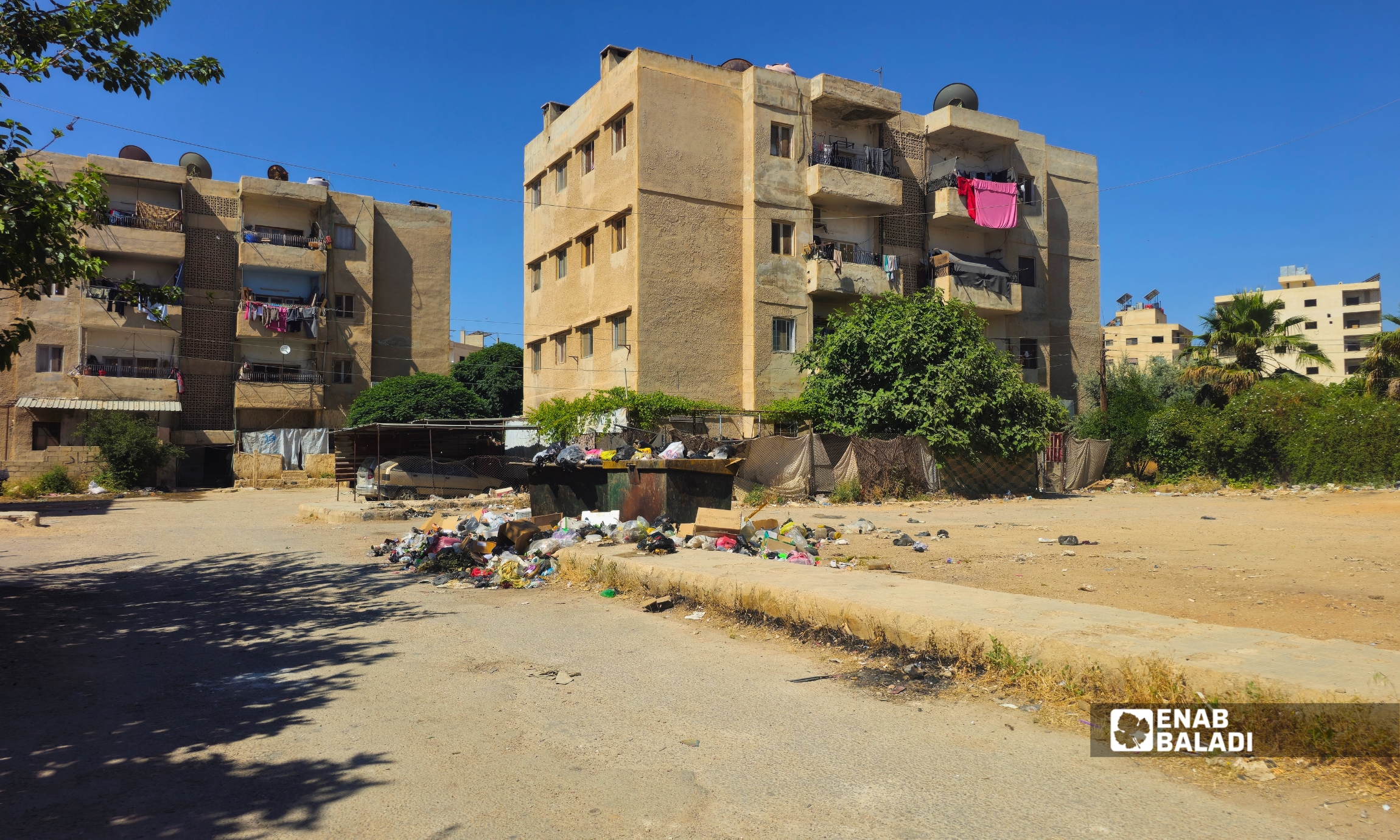 تراكم القمامة بجوار إحدى الحاويات في مساكن الصراع قرب جديدة عرطوز
